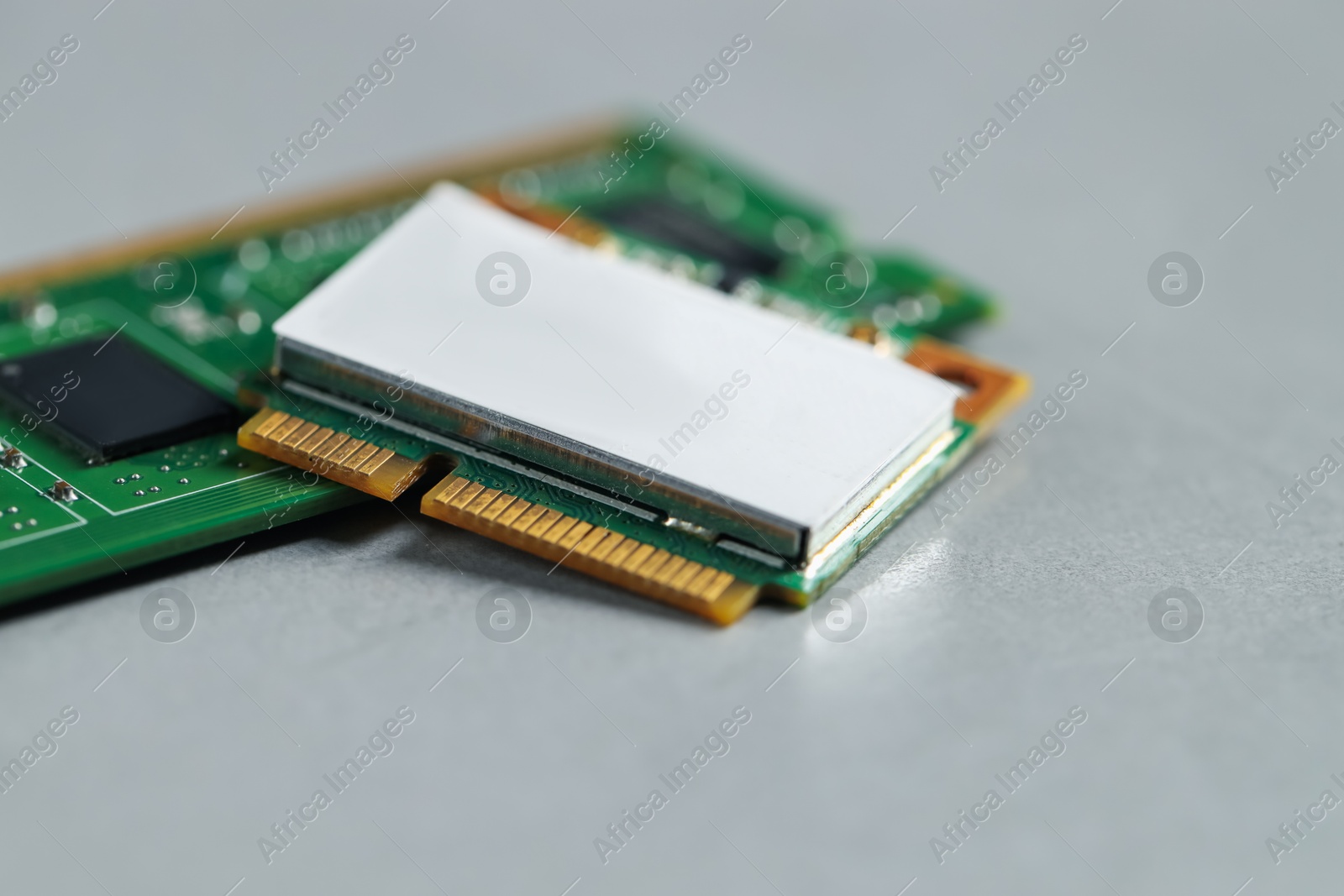 Photo of Wi-Fi card and RAM chip on grey table, closeup