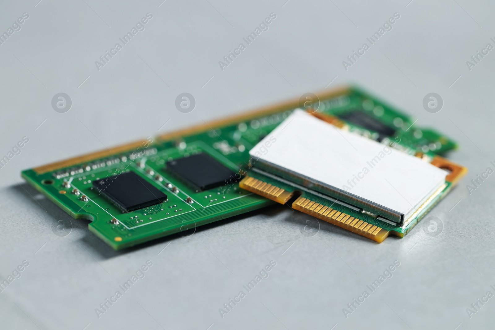 Photo of Wi-Fi card and RAM chip on grey table, closeup