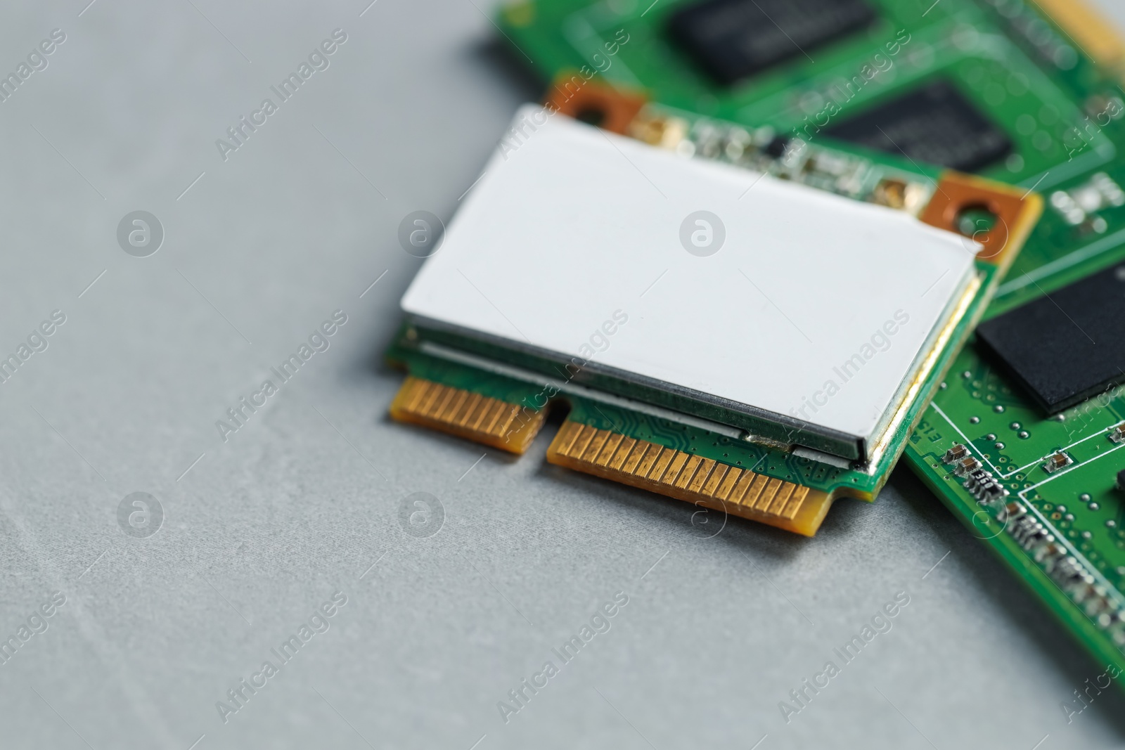 Photo of Wi-Fi card and RAM chip on grey table, closeup