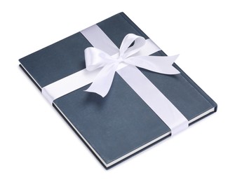 Photo of One book with silk ribbon as gift isolated on white