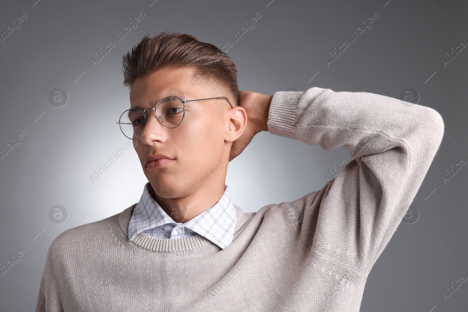 Photo of Handsome young man with stylish haircut on grey background