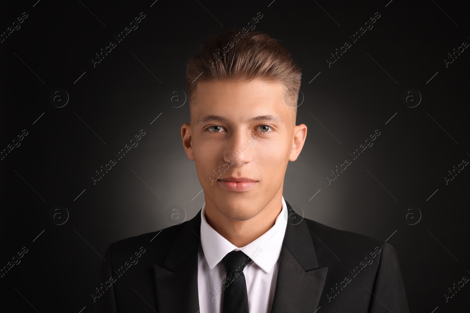 Photo of Confident young man with stylish haircut on black background