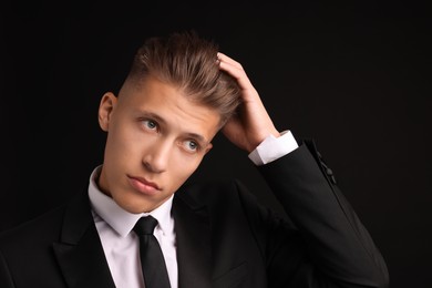 Photo of Confident young man with stylish haircut on black background