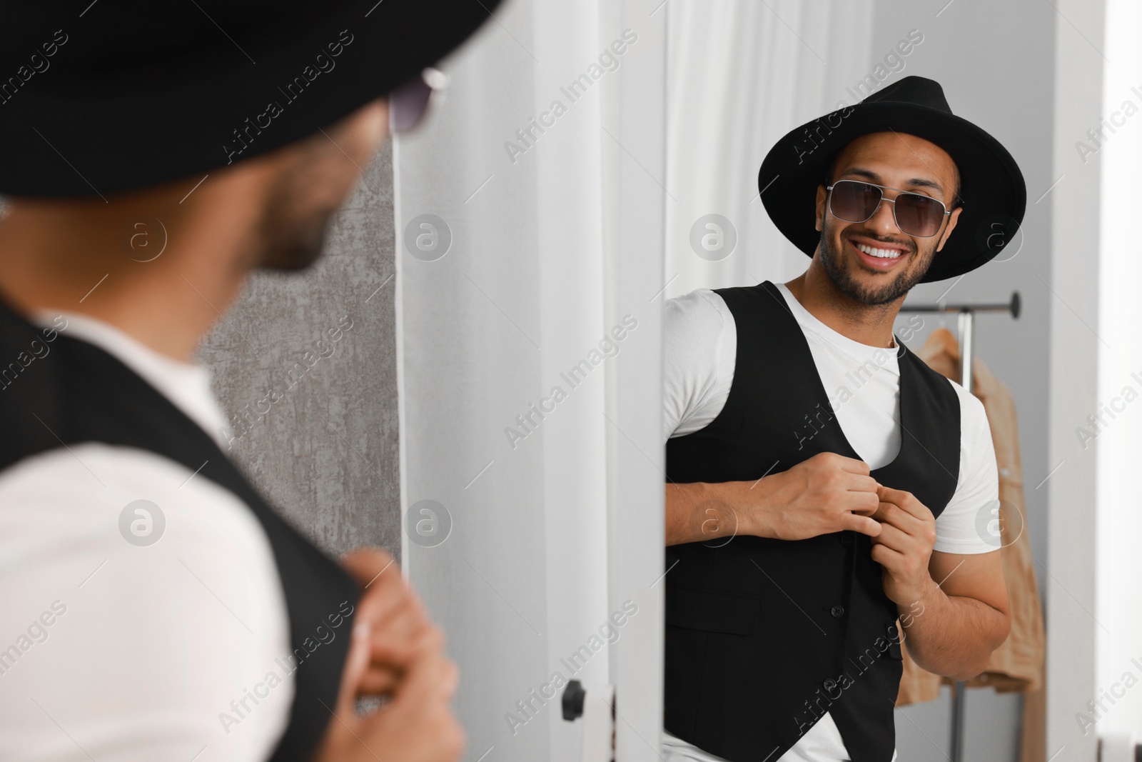 Photo of Smiling man looking at mirror at home