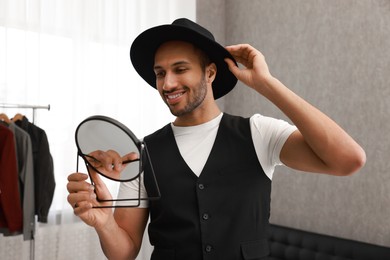 Smiling man looking at mirror at home