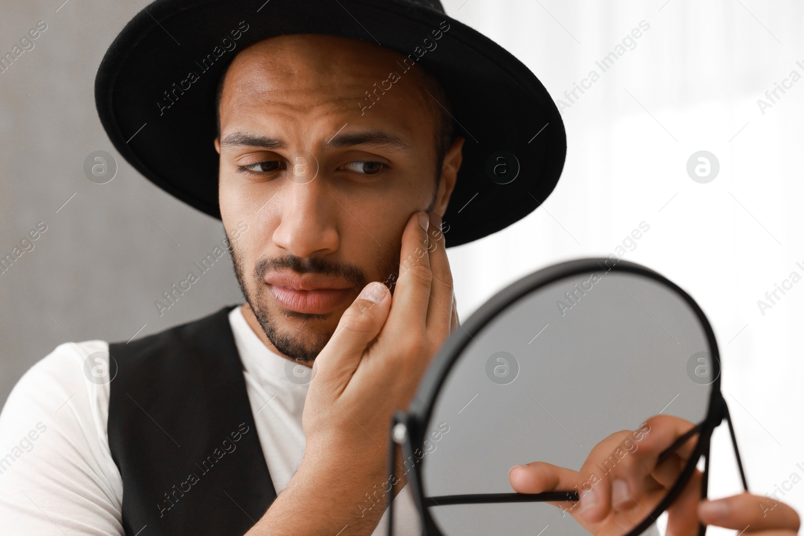 Photo of Handsome man looking at mirror at home