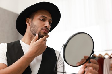 Photo of Handsome man looking at mirror at home