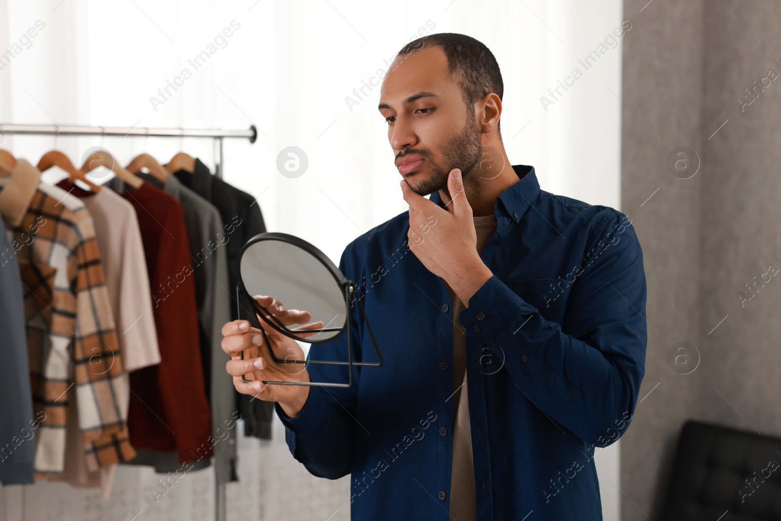 Photo of Handsome man looking at mirror at home