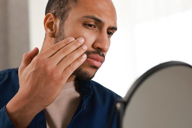 Photo of Handsome man looking at mirror at home