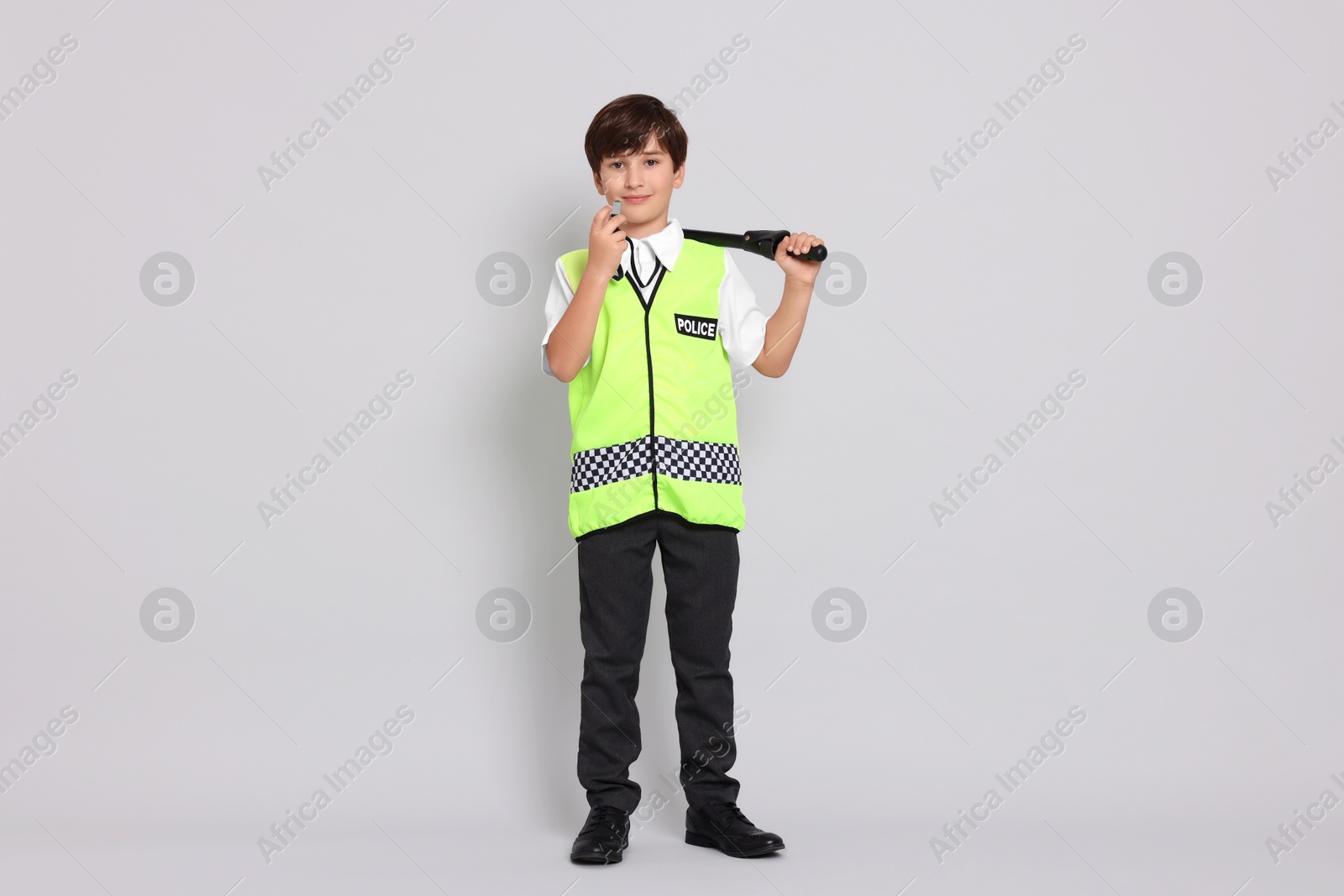 Photo of Boy pretending to be policeman on light grey background. Dreaming of future profession