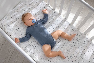 Photo of Cute baby sleeping in crib at home, top view