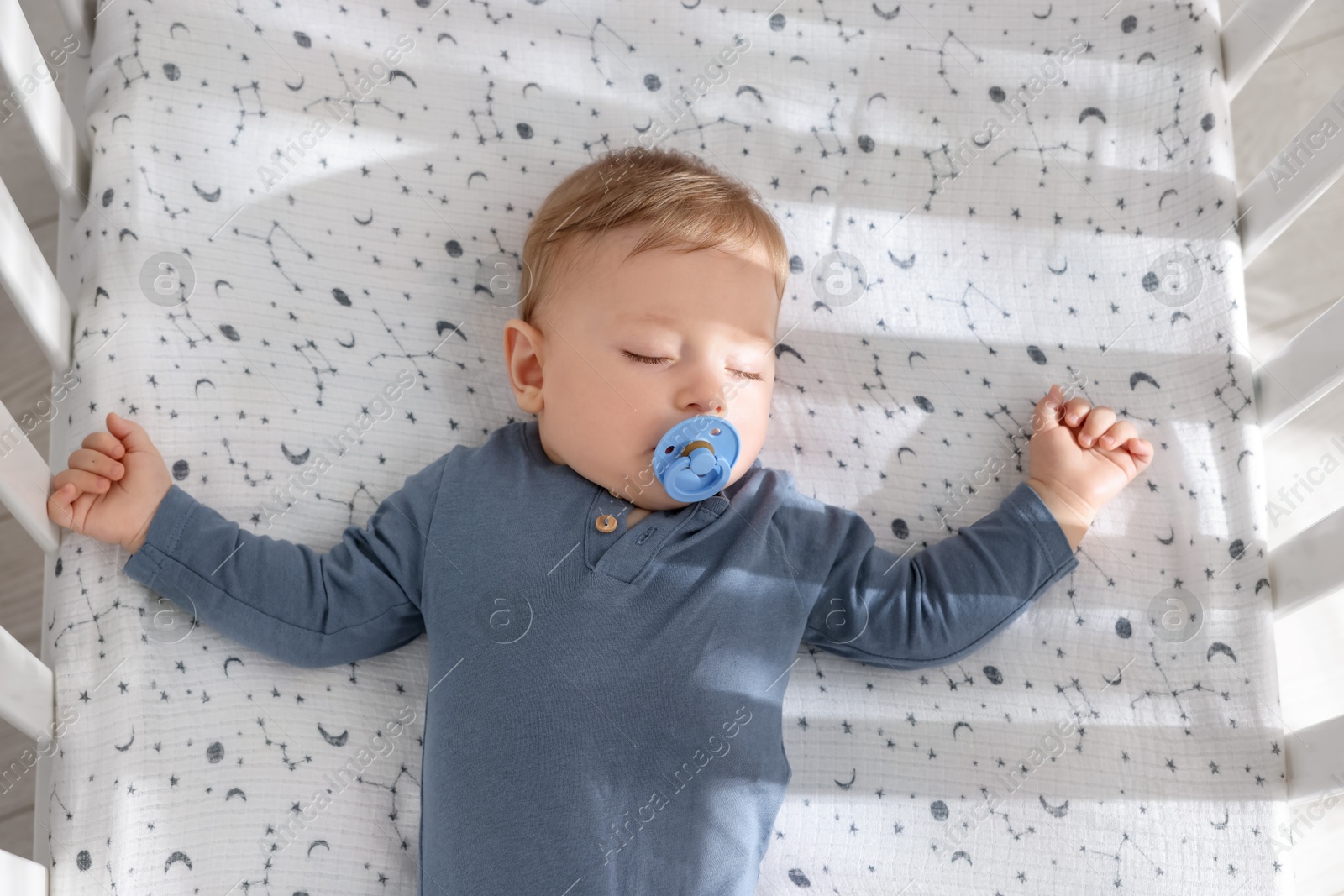 Photo of Cute baby sleeping in crib at home, top view