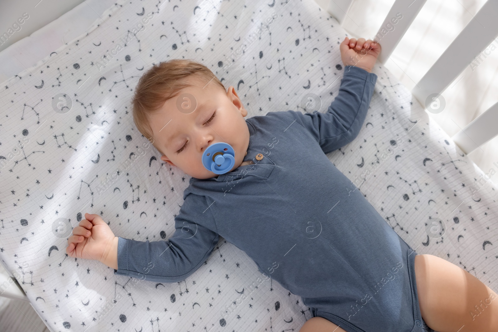 Photo of Cute baby sleeping in crib at home, top view