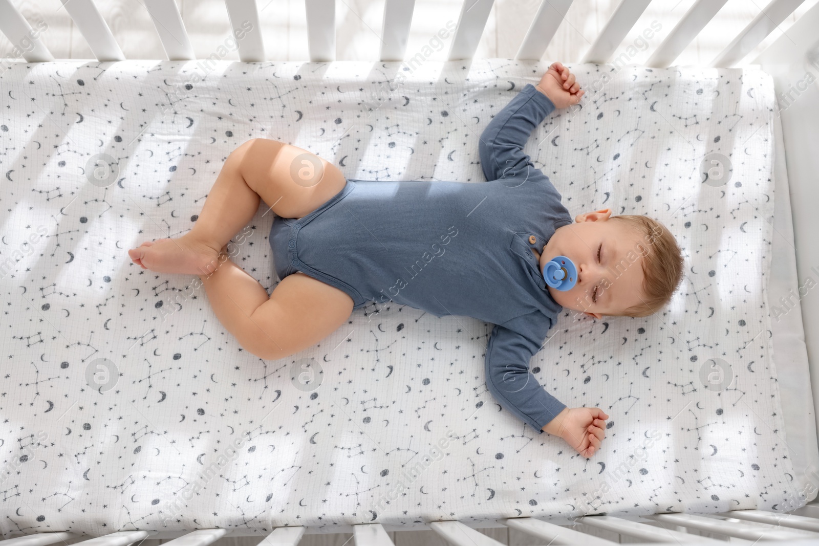 Photo of Cute baby sleeping in crib at home, top view