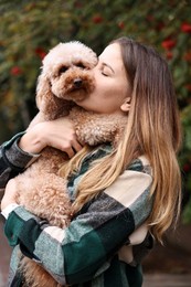 Photo of Woman with cute Toy Poodle dog in park