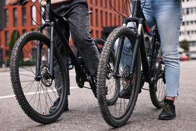 Photo of Couple with bicycles spending time together outdoors, closeup