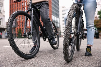 Photo of Couple with bicycles spending time together outdoors, closeup