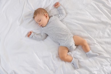 Photo of Cute little baby sleeping on bed at home, top view