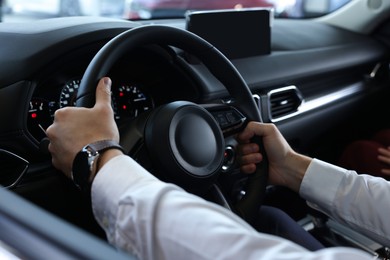 Photo of Man inside new car in salon, closeup