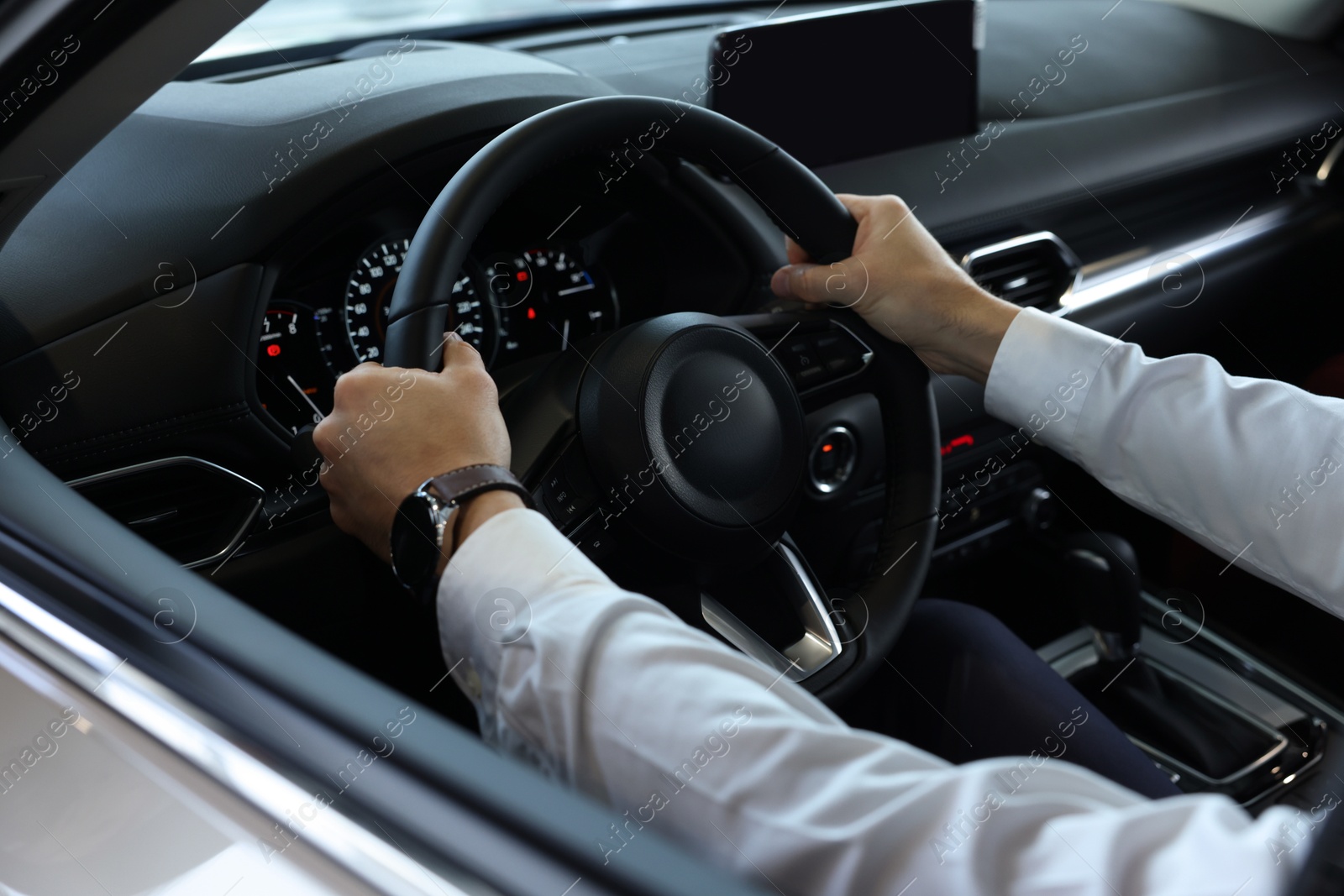 Photo of Man inside new car in salon, closeup