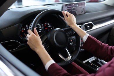 Photo of Young woman inside new car in salon, closeup