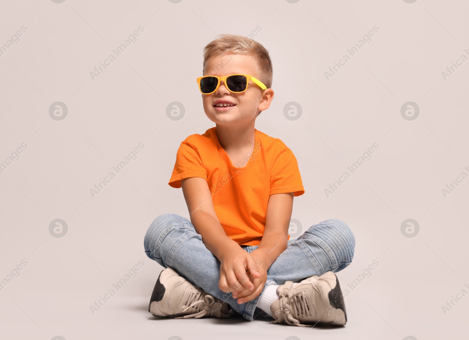 Photo of Little boy with sunglasses on light grey background