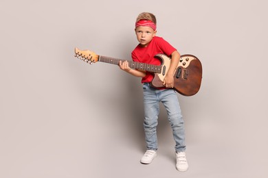 Photo of Little boy with guitar on light grey background