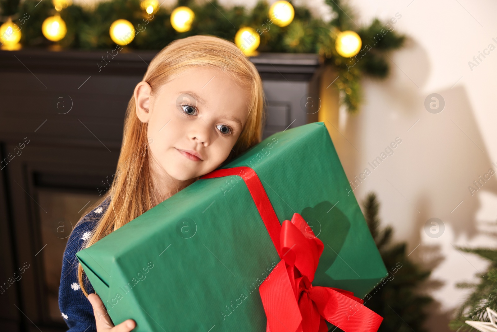 Photo of Little girl with Christmas gift at home