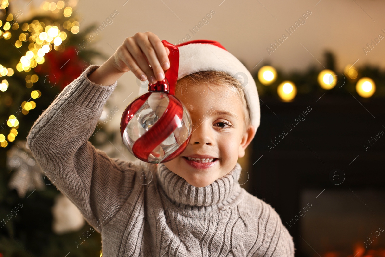 Photo of Little boy with Christmas ornament at home