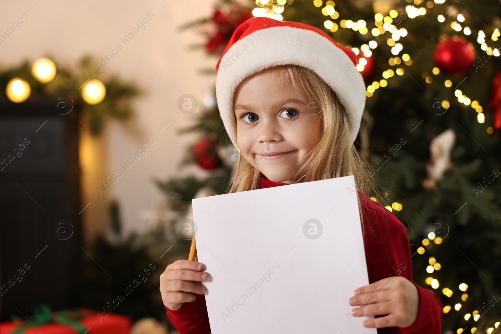 Photo of Little girl with letter for Santa Claus at home, space for text. Christmas celebration