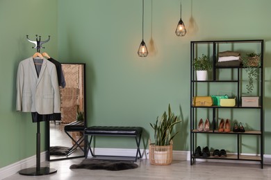 Photo of Stylish hallway interior with mirror and shelving unit