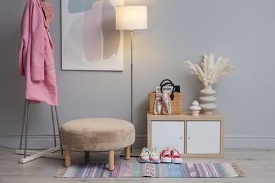 Stylish hallway interior with pouf and lamp