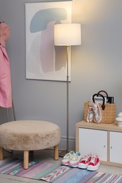 Photo of Stylish hallway interior with pouf and lamp