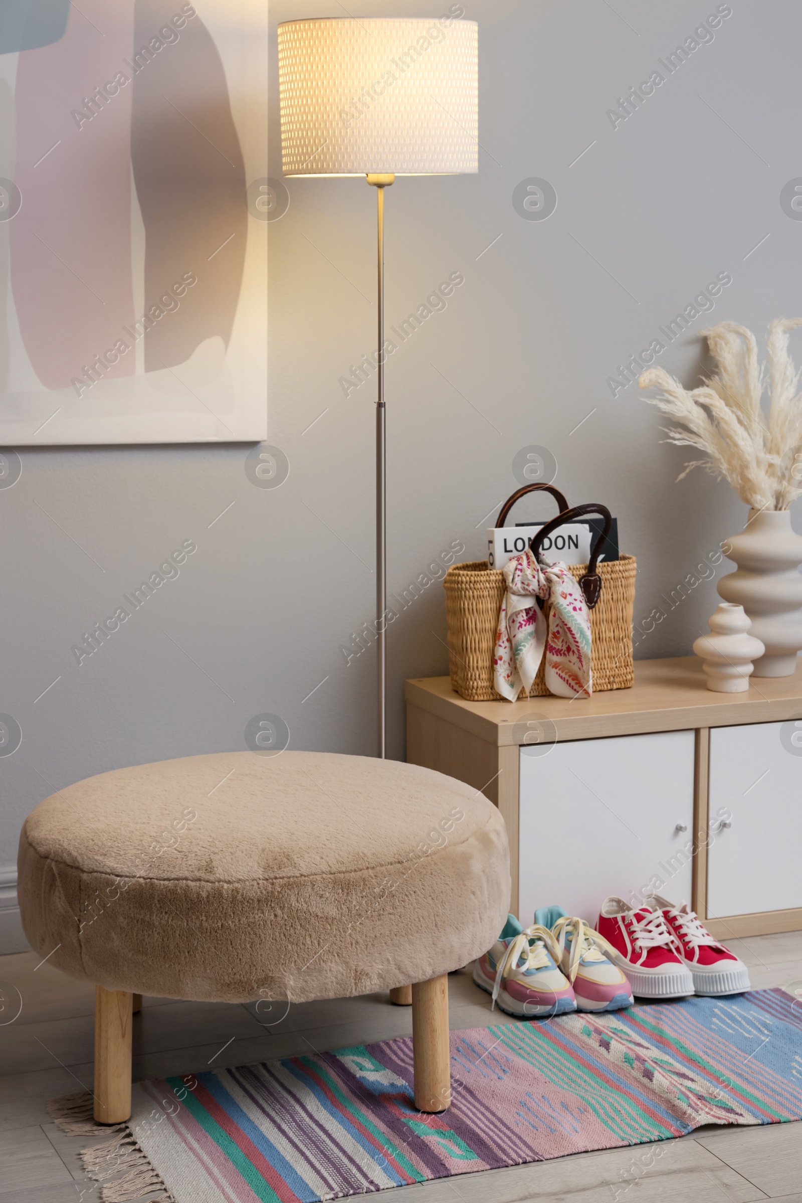 Photo of Stylish hallway interior with pouf and lamp