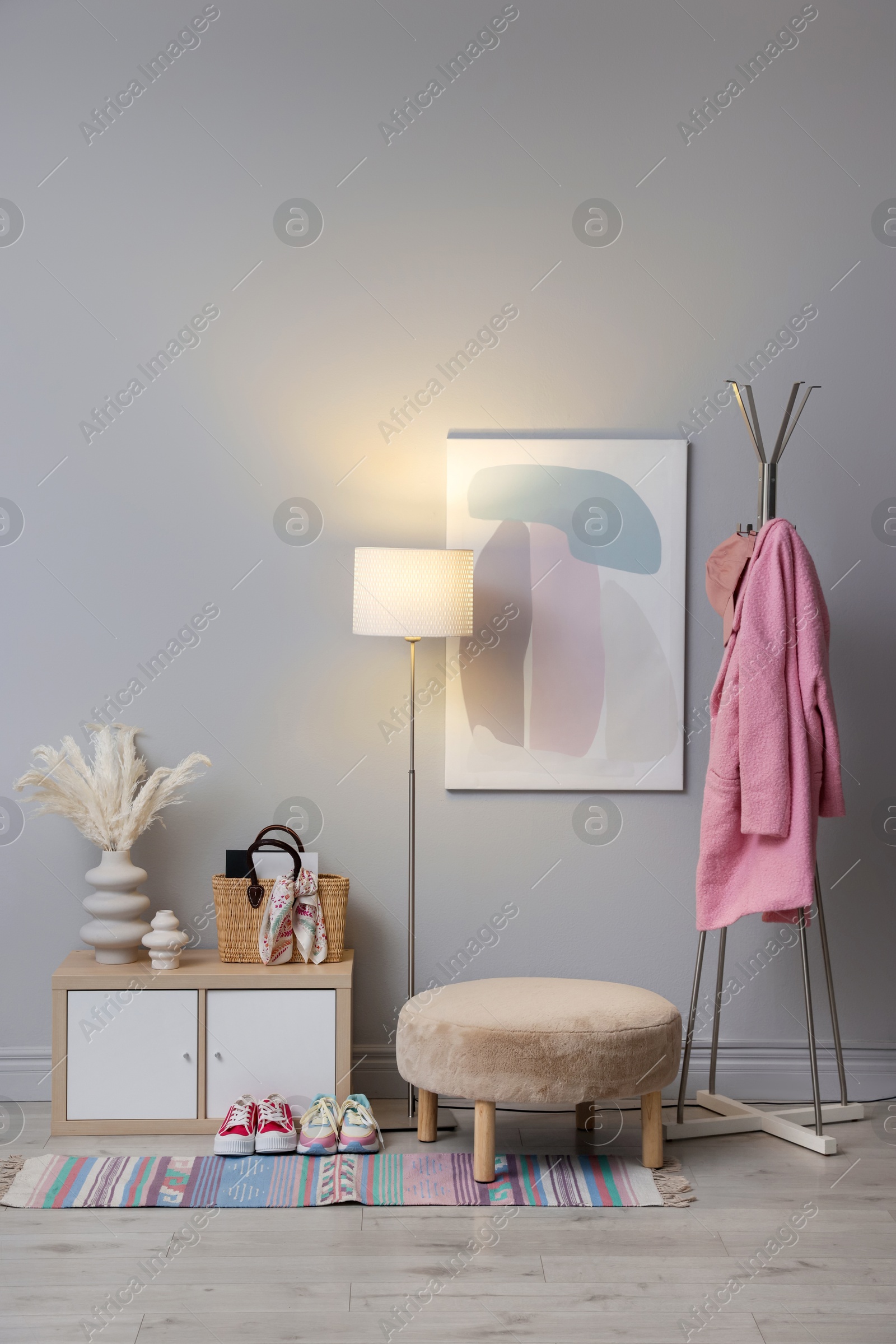 Photo of Stylish hallway interior with pouf and lamp