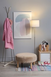 Photo of Stylish hallway interior with pouf and lamp