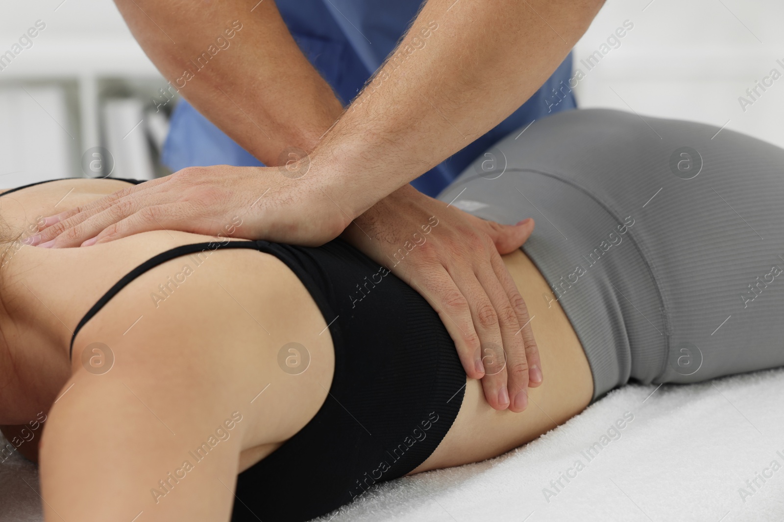 Photo of Osteopath massaging woman's back in clinic, closeup. Manual therapy