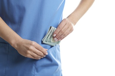 Photo of Corruption concept. Doctor putting dollar banknotes into her pocket on white background, closeup