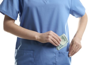 Photo of Corruption concept. Doctor putting dollar banknotes into her pocket on white background, closeup