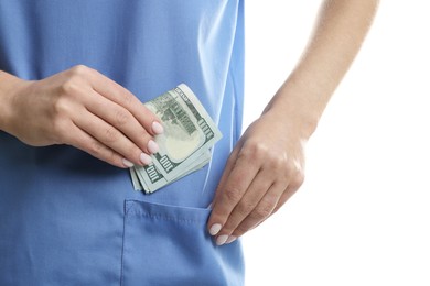 Photo of Corruption concept. Doctor putting dollar banknotes into her pocket on white background, closeup