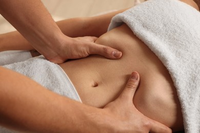 Osteopath massaging woman's belly indoors, closeup. Manual therapy