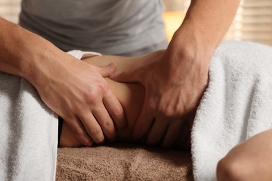 Osteopath massaging woman's belly indoors, closeup. Manual therapy