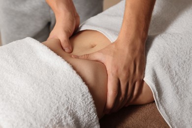 Photo of Osteopath massaging woman's belly indoors, closeup. Manual therapy