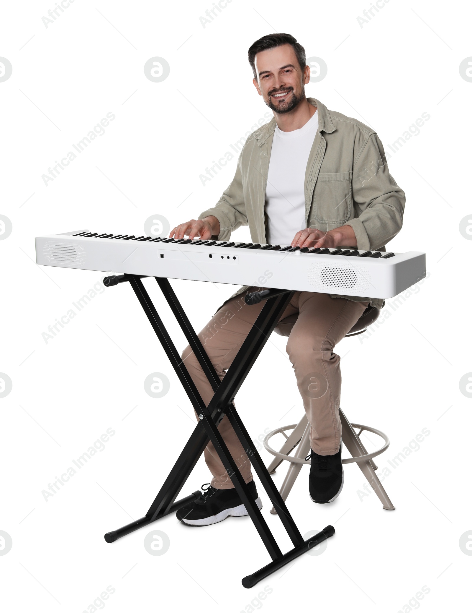 Photo of Smiling man playing synthesizer on white background