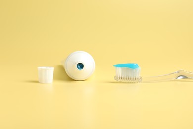 Photo of Toothbrush with toothpaste and tube on yellow background