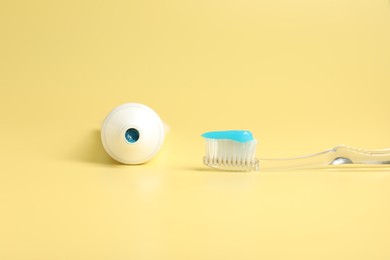 Photo of Toothbrush with toothpaste and tube on yellow background