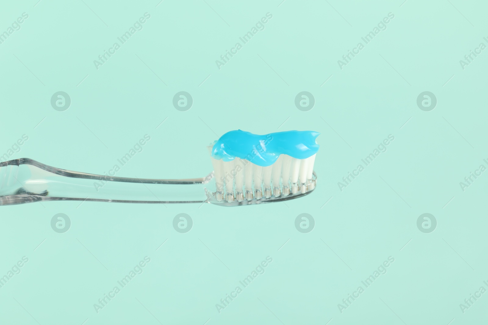 Toothbrush with toothpaste on light blue background, closeup Photo of Toothbrush with toothpaste on light blue background, closeup