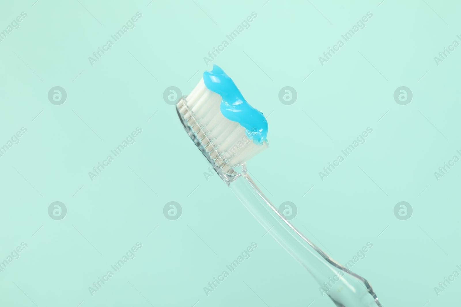 Toothbrush with toothpaste on light blue background, closeup Photo of Toothbrush with toothpaste on light blue background, closeup