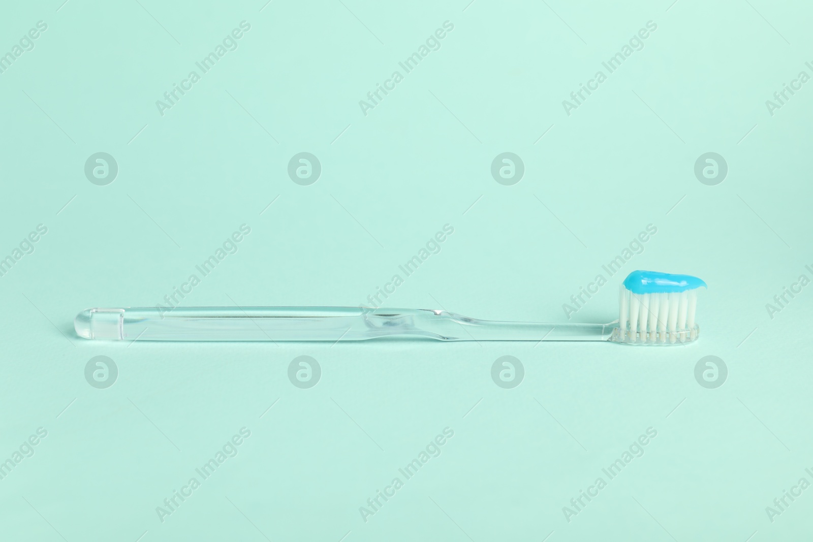 Photo of Toothbrush with toothpaste on light blue background