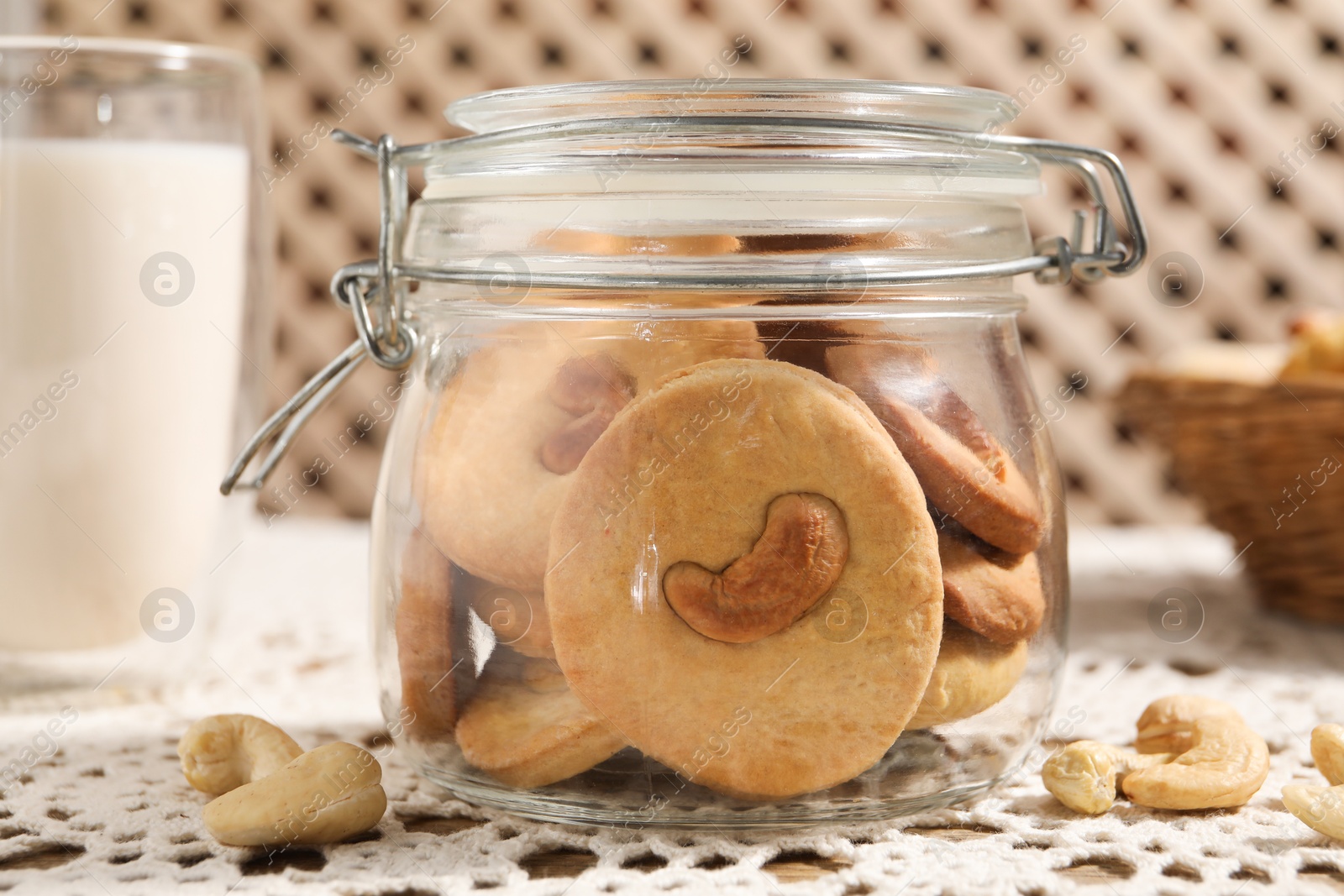 Photo of Tasty cashew cookies in jar on table, closeup